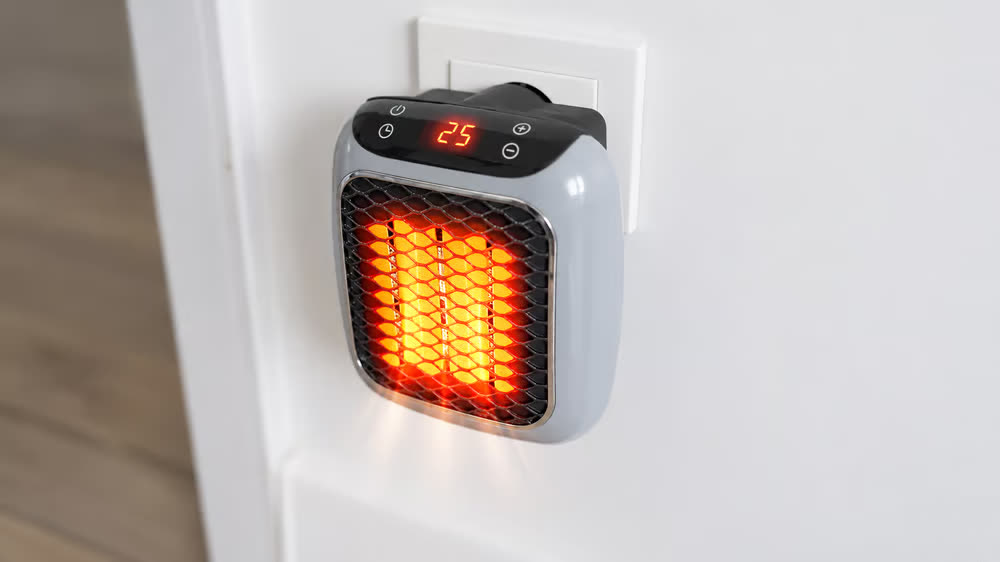 RapidHeat Heater plugged directly into a white wall socket with its heating element glowing